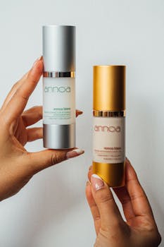Close-up of hands holding elegant skincare bottles on a white background, showcasing luxury beauty packaging.