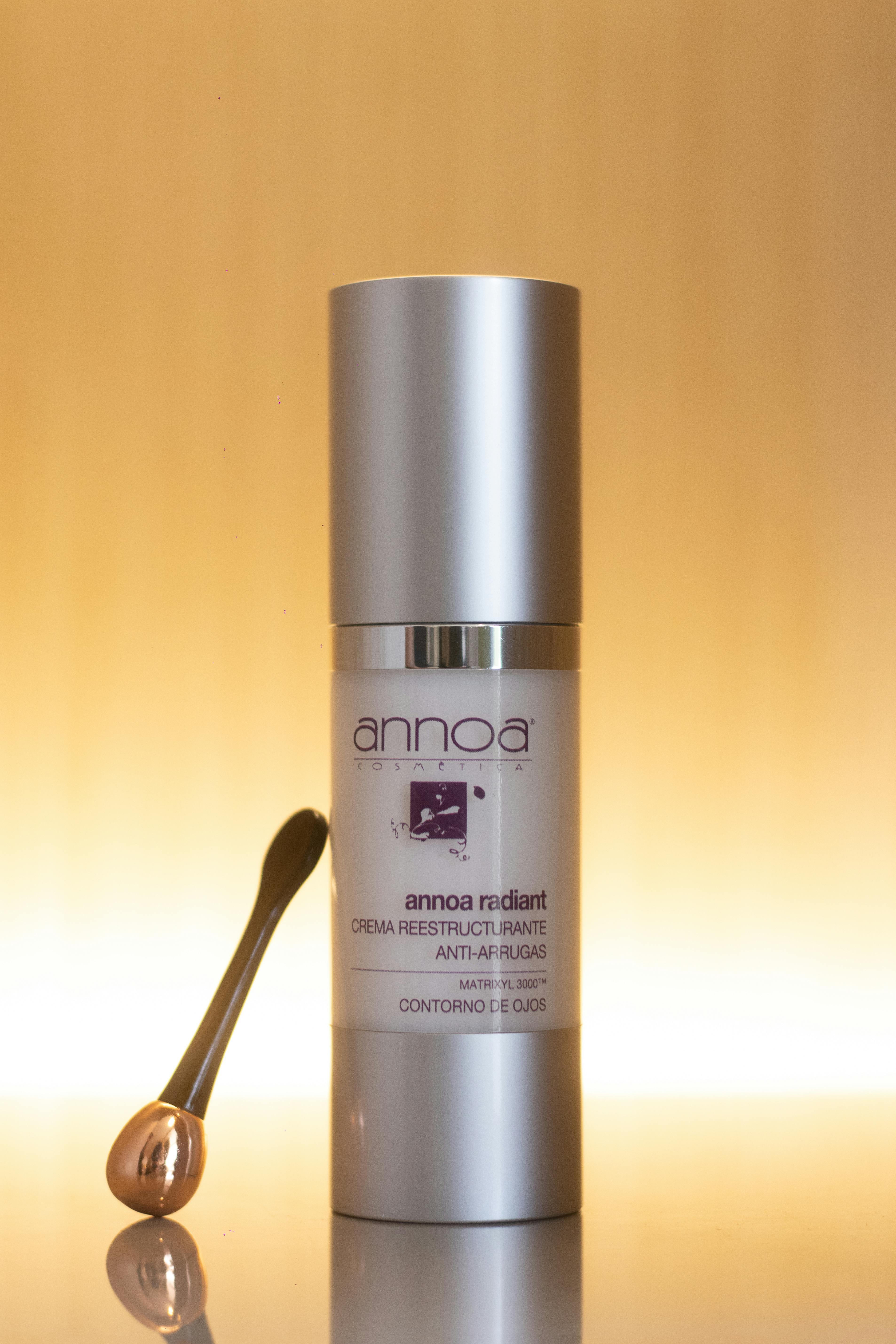 Luxury anti-wrinkle cream with a sleek applicator on a warm gradient background.