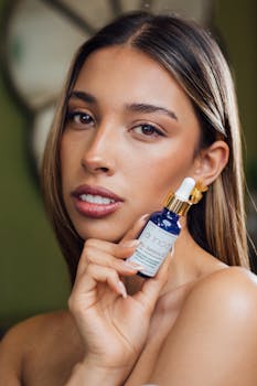 Close-up portrait of a young woman with a skincare serum bottle, soft natural lighting.