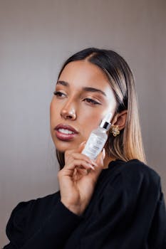 Portrait of a woman showcasing a skincare serum bottle, with a focus on youthful beauty and elegance.