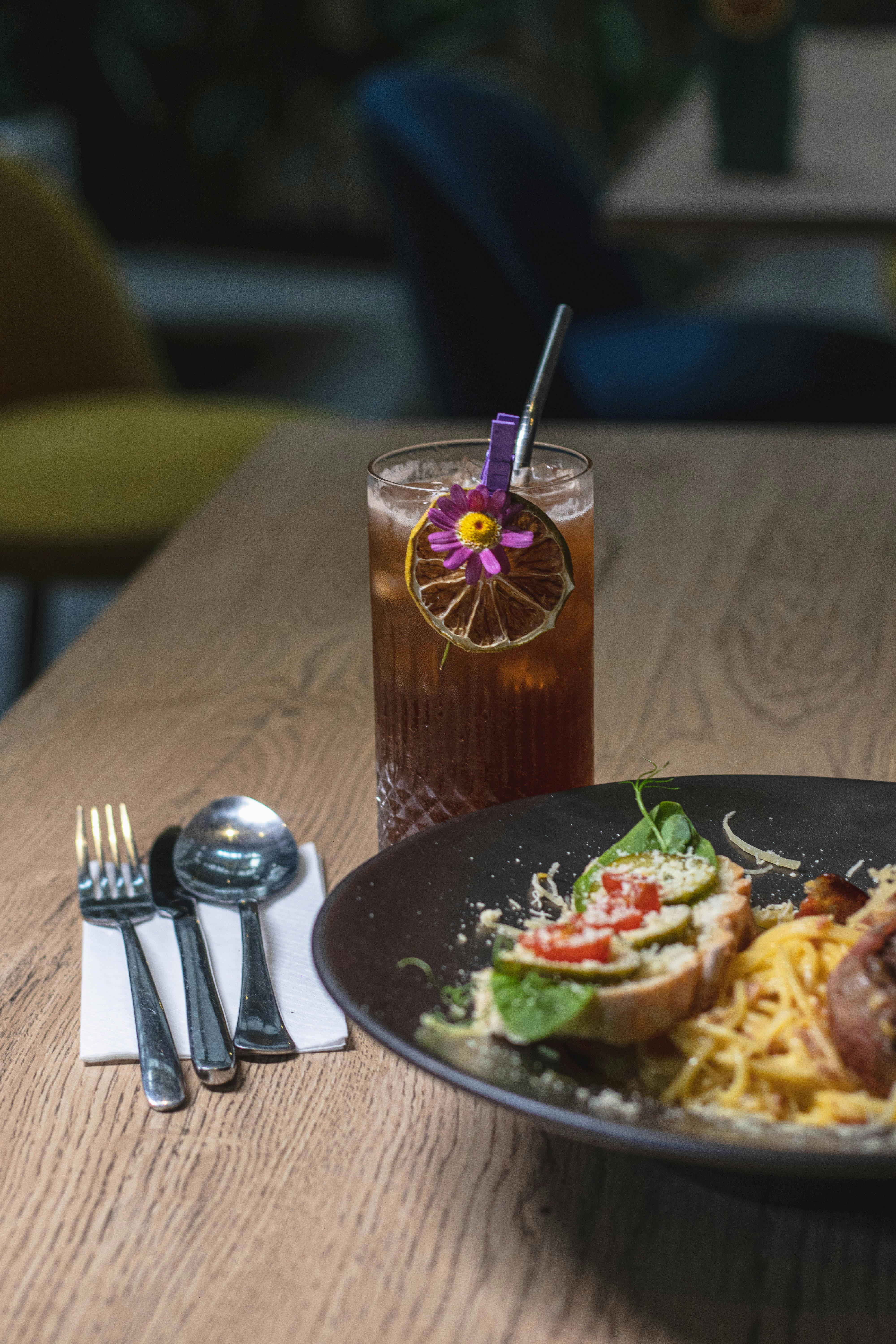 A stylish dining setup featuring a spaghetti dish and a refreshing iced tea with garnishment.