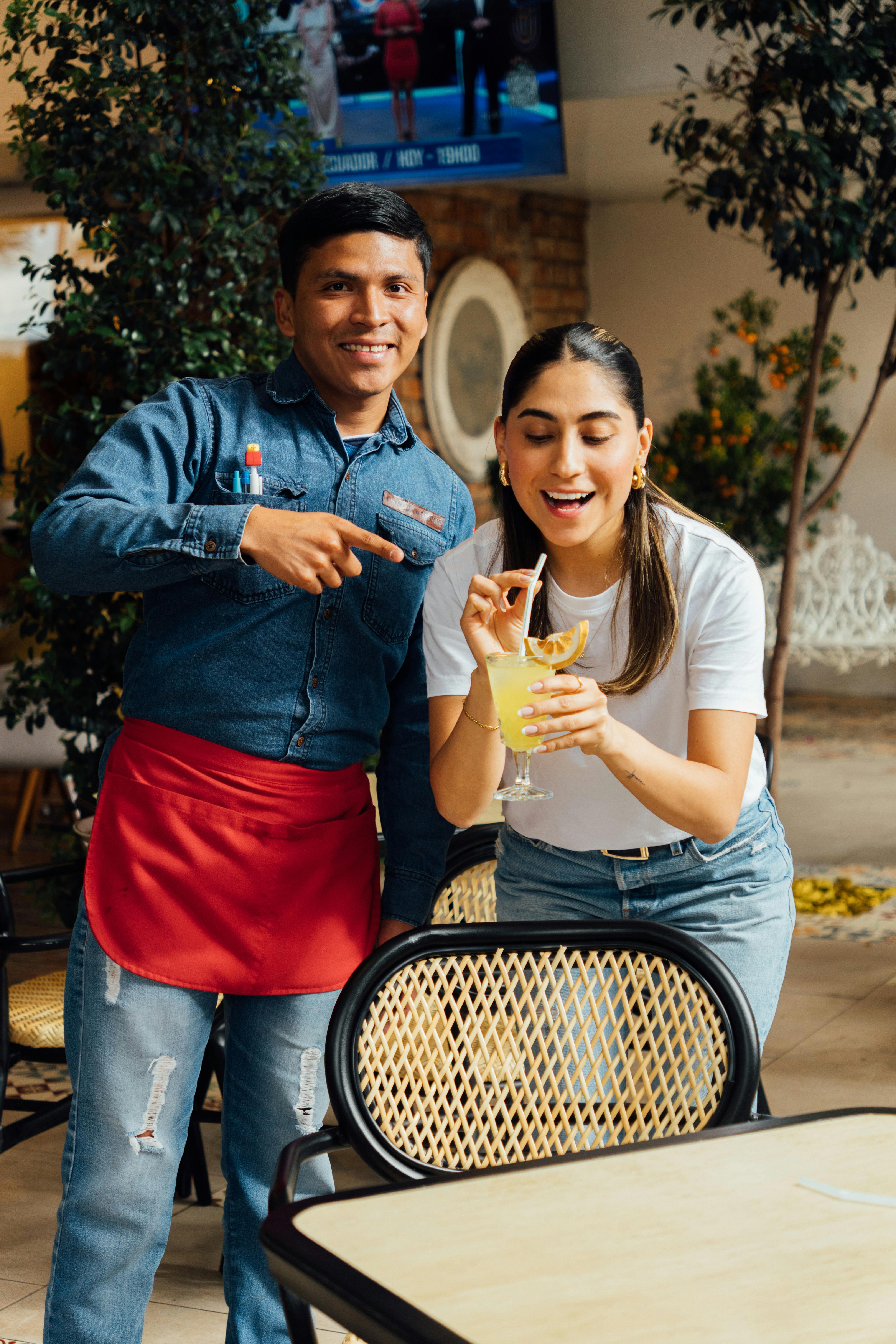 Happy couple enjoying a refreshing drink inside a cozy cafe environment.