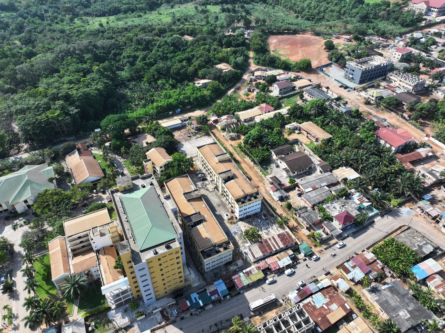 Aerial view over Sowutoum, Ghana showcasing residential areas and lush greenery.
