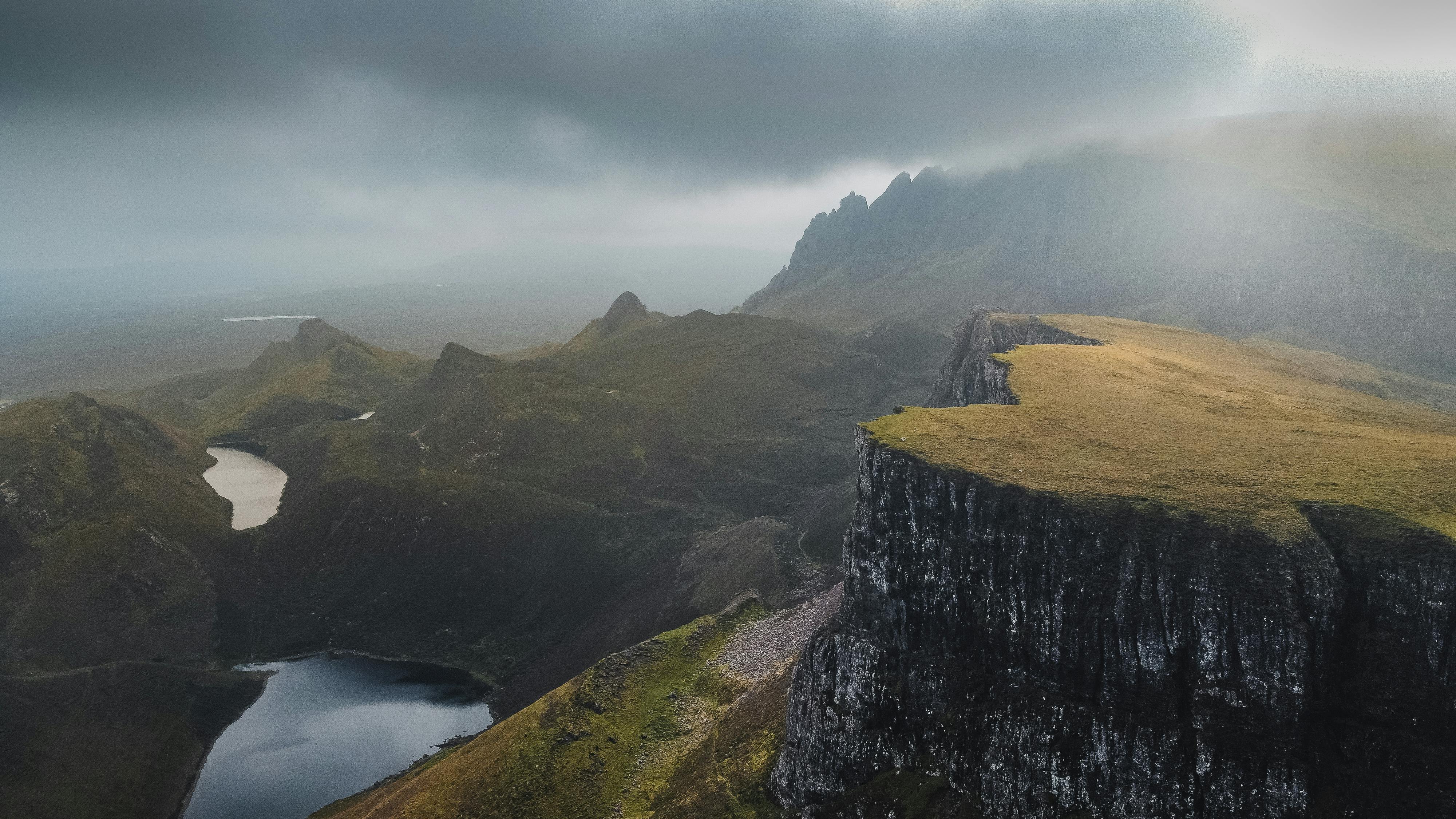 Aerial view of the dramatic Quiraing landscape on the Isle of Skye, Scotland under cloudy skies.