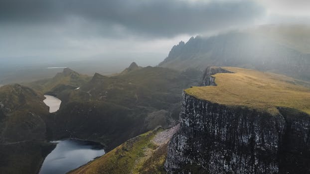 Aerial view of the dramatic Quiraing landscape on the Isle of Skye, Scotland under cloudy skies.