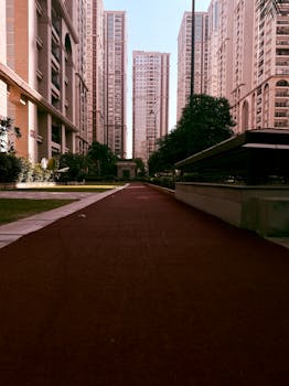 View of contemporary high-rise apartment buildings surrounded by lush greenery in a cityscape.
