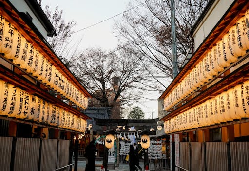 A scenic view of glowing lanterns in a Japanese shrine at dusk, evoking a tranquil atmosphere.
