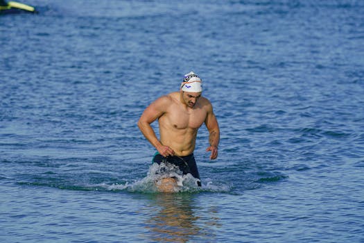Fit adult male swimmer emerging from the sea in Kuşadası, Türkiye.