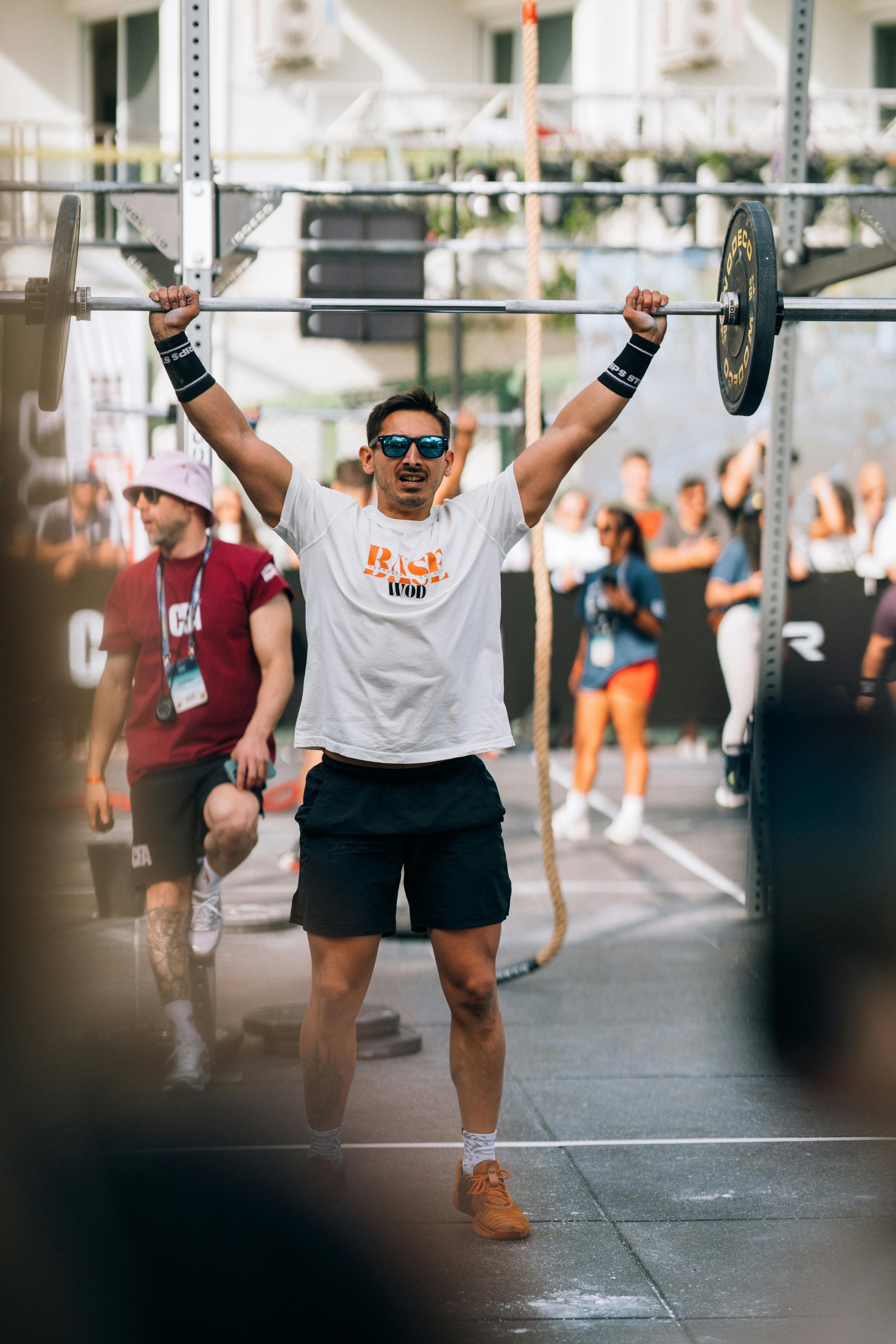 Man lifting barbell during outdoor fitness competition in Kuşadası, Türkiye.