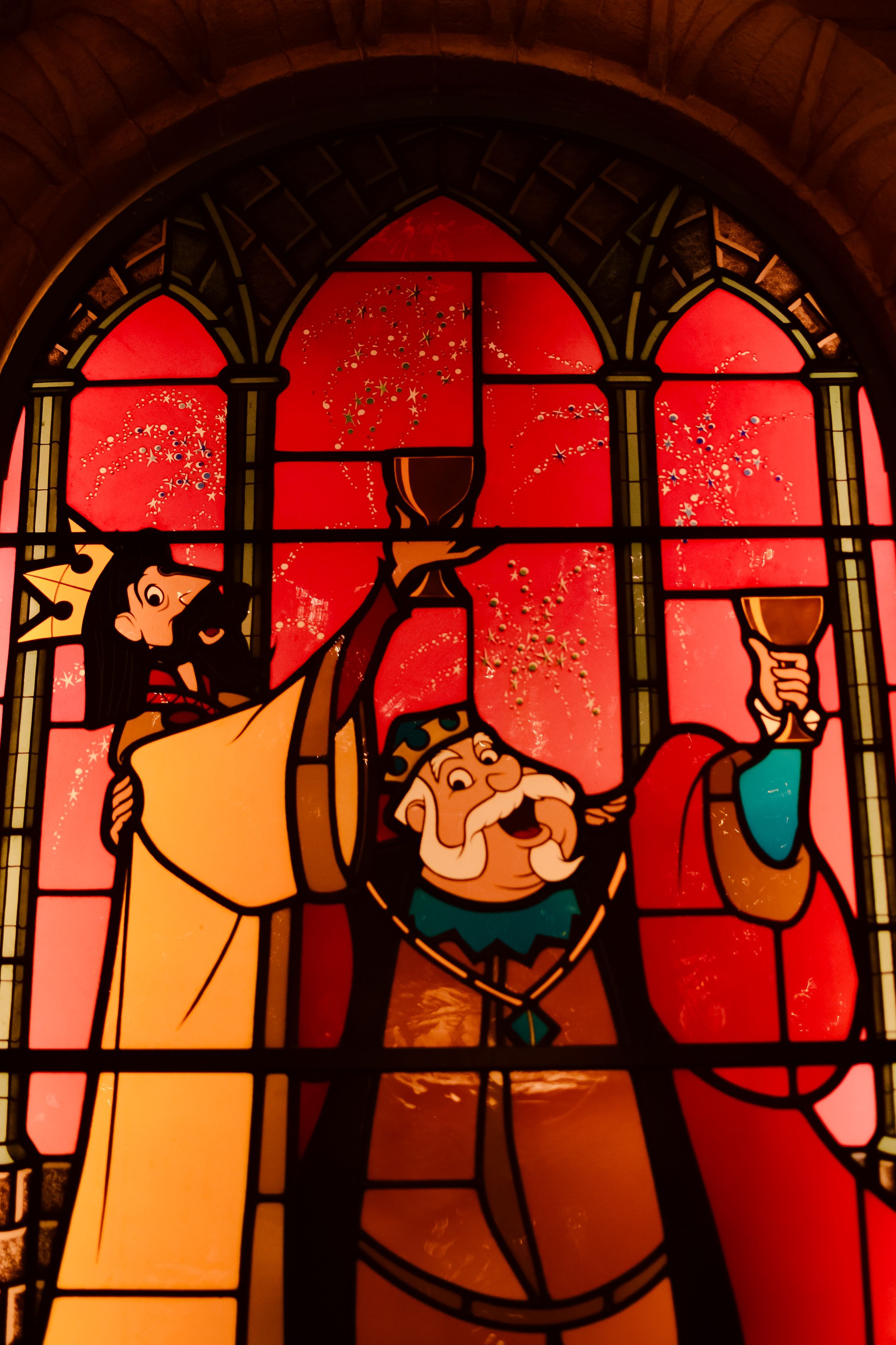 Vibrant stained glass window depicting medieval figures in Coupvray, France.