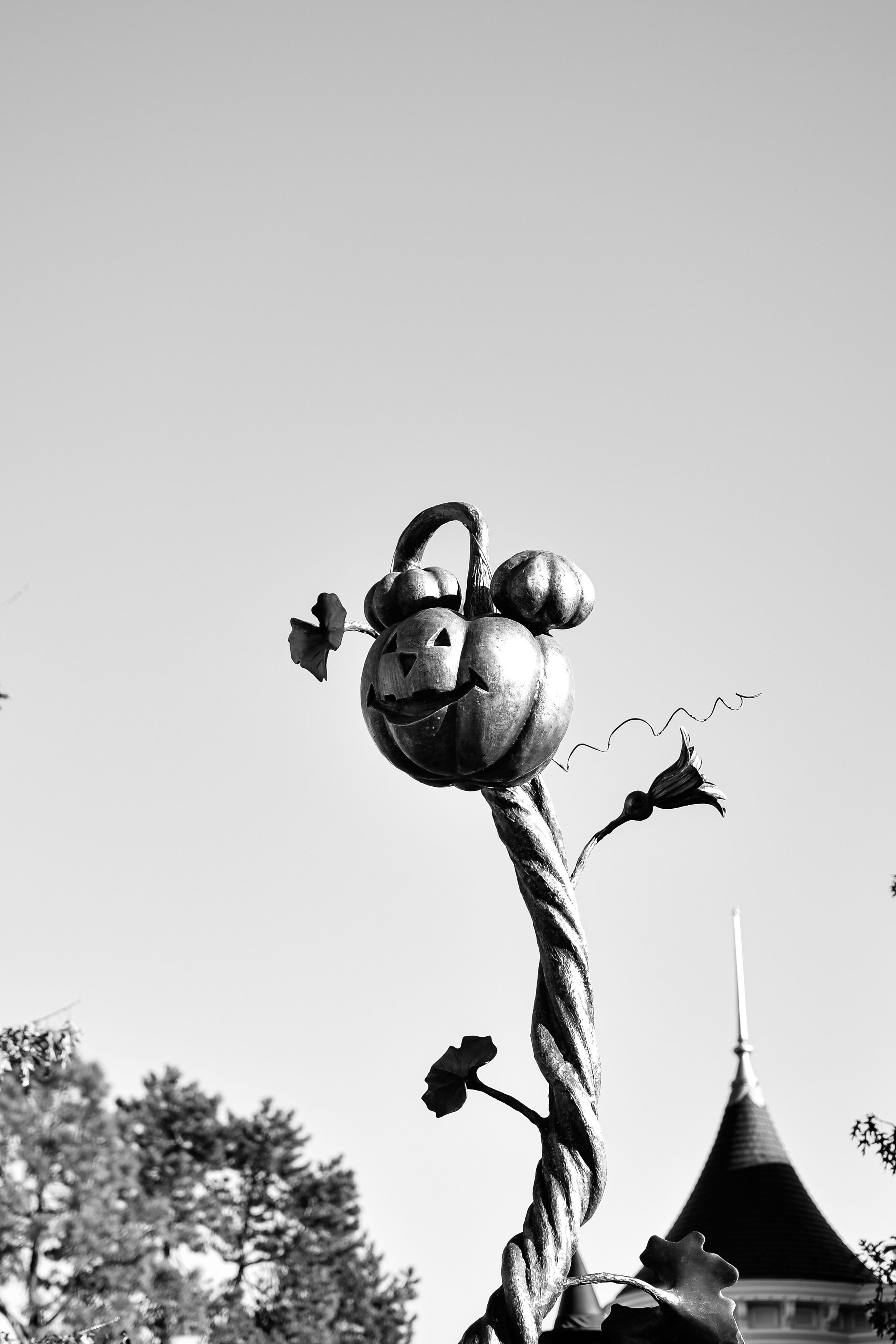 Black and white photo of a Halloween-themed pumpkin sculpture at a park.