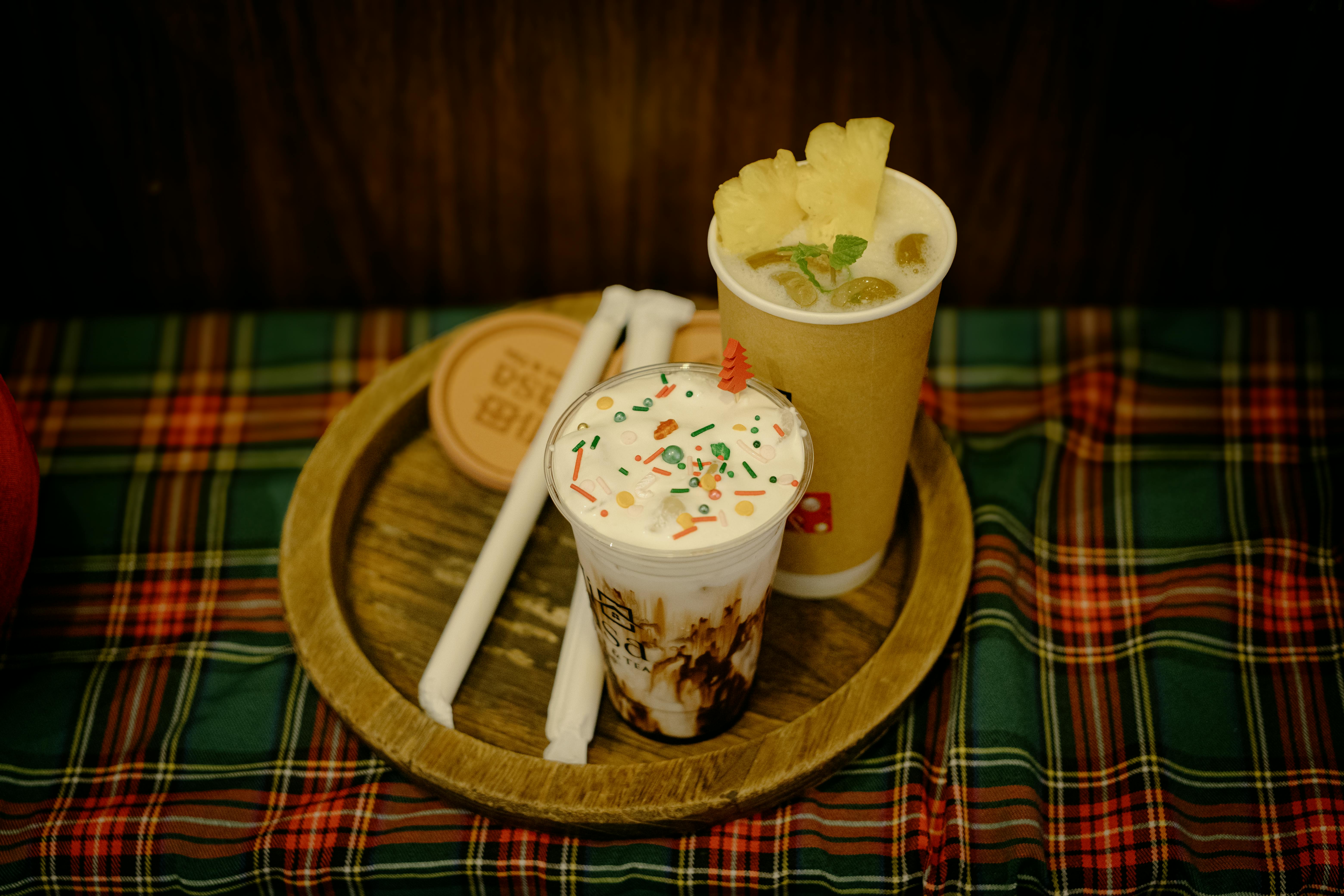 Gratis Due drink festivi con granella e ananas, disposti su una tovaglia scozzese, per creare un'atmosfera festosa. Foto a disposizione