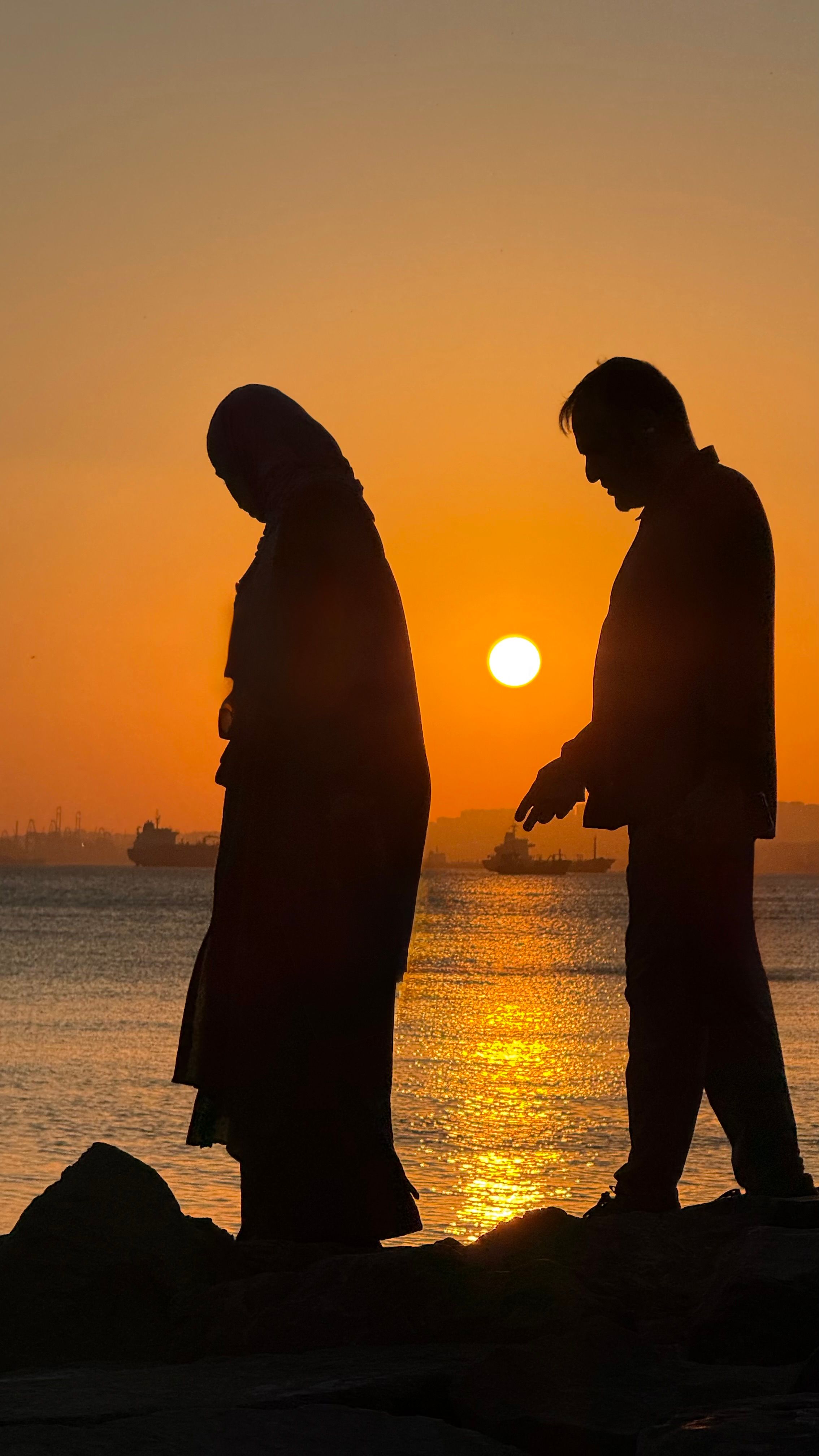 Silhouette of Couple Walking at Sunset by the Coast · Free Stock Photo