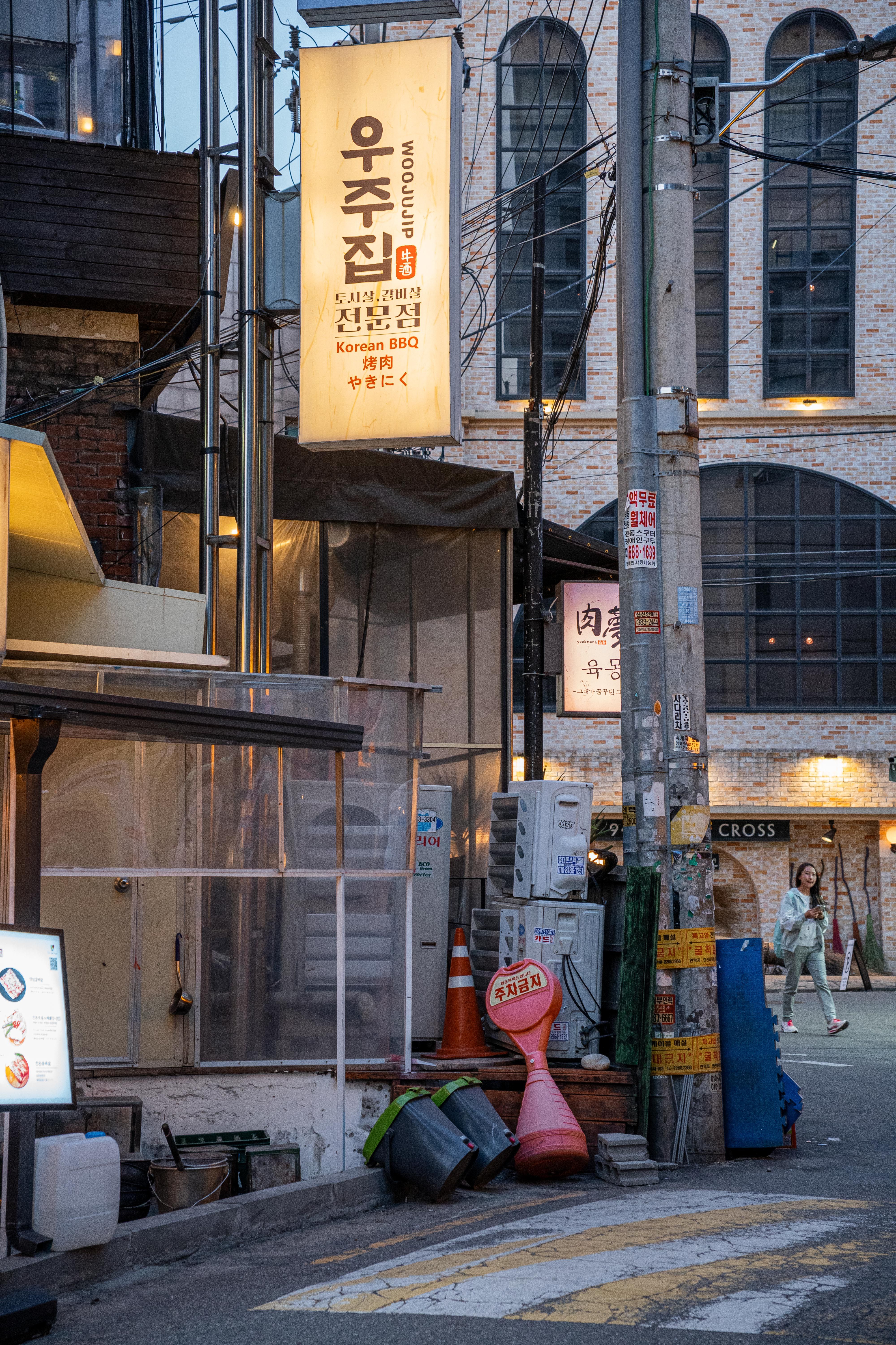 Urban street view of Seoul featuring a Korean BBQ sign at twilight.