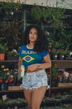 Young woman in a Brazil shirt posing in a vibrant plant store.