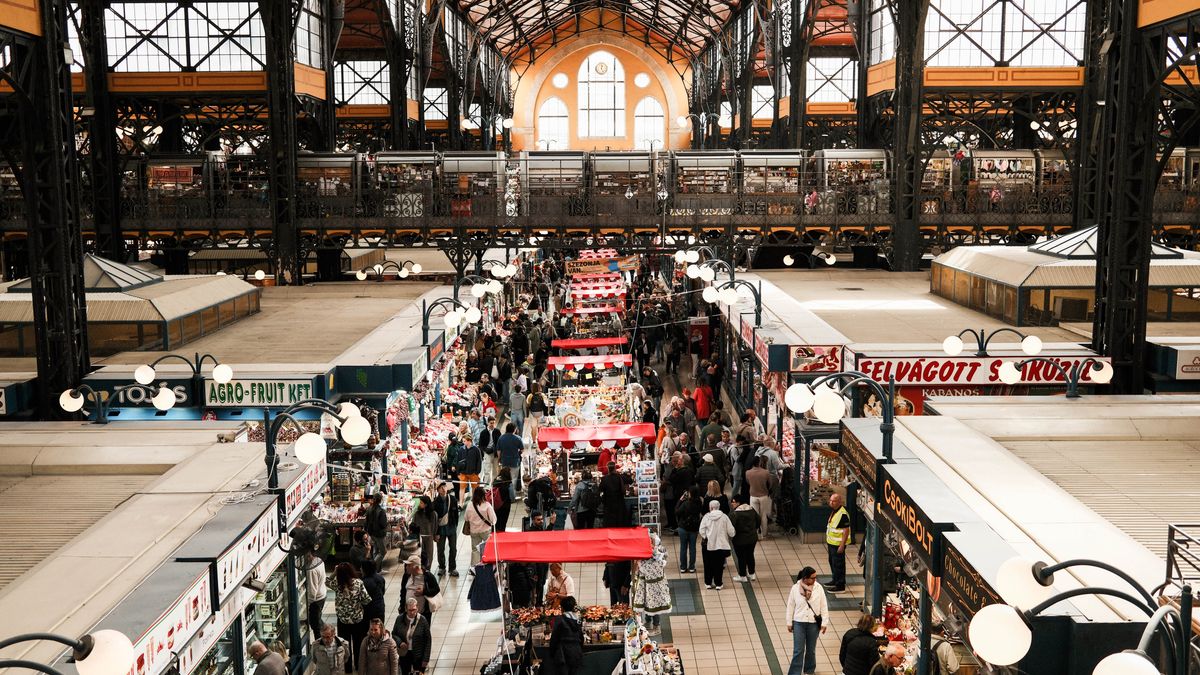 Explore the vibrant Budapest Central Market Hall filled with shoppers and vendors captured from above.