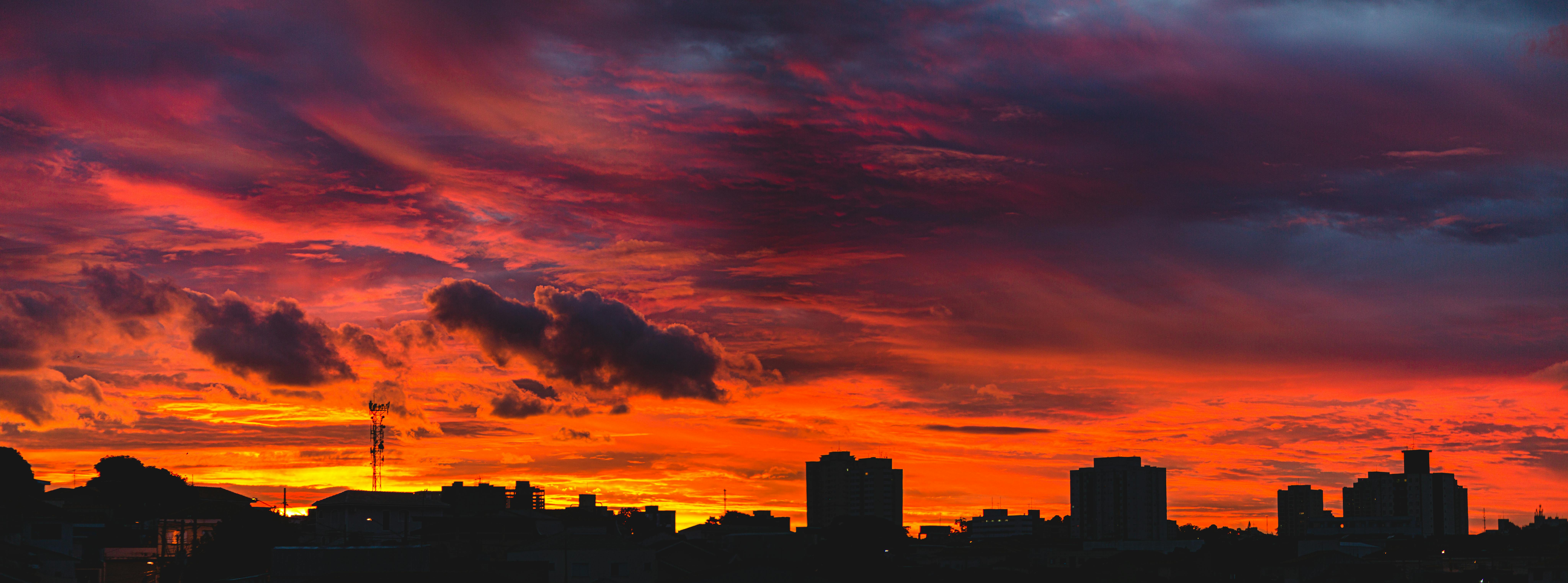 戏剧性的红橙色日落天空映衬着令人惊叹的城市景观轮廓