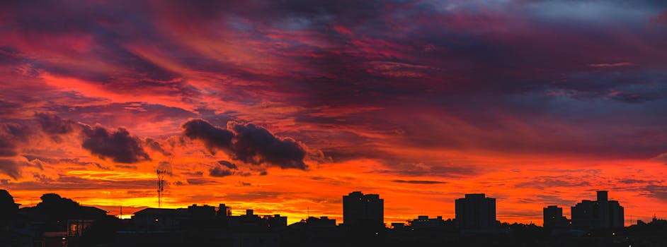 戏剧性的红橙色日落天空映衬着令人惊叹的城市景观轮廓