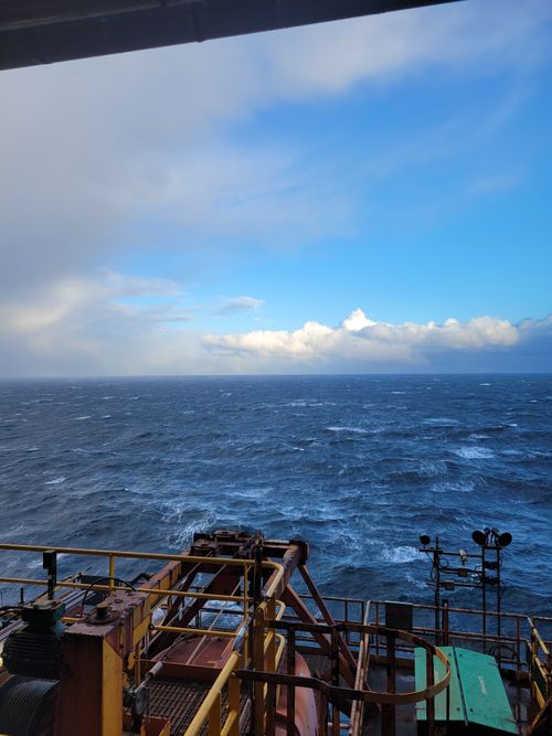 Free View from an offshore oil rig showcasing a vast ocean horizon under a vivid sky. Stock Photo