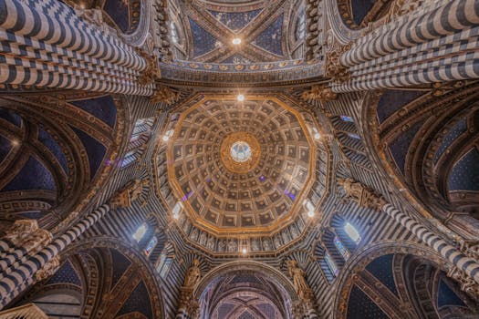 Intricate view of the Siena Cathedral's ornate Gothic dome ceiling with vibrant patterns and designs.
