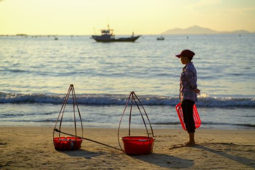 Free A tranquil morning scene at Da Nang beach with a fisherman and traditional baskets. Stock Photo