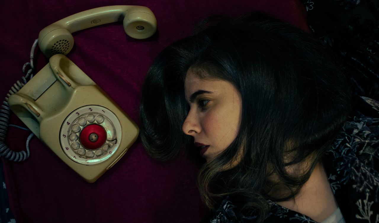 artistic composition of a woman and a classic rotary phone on a rich r