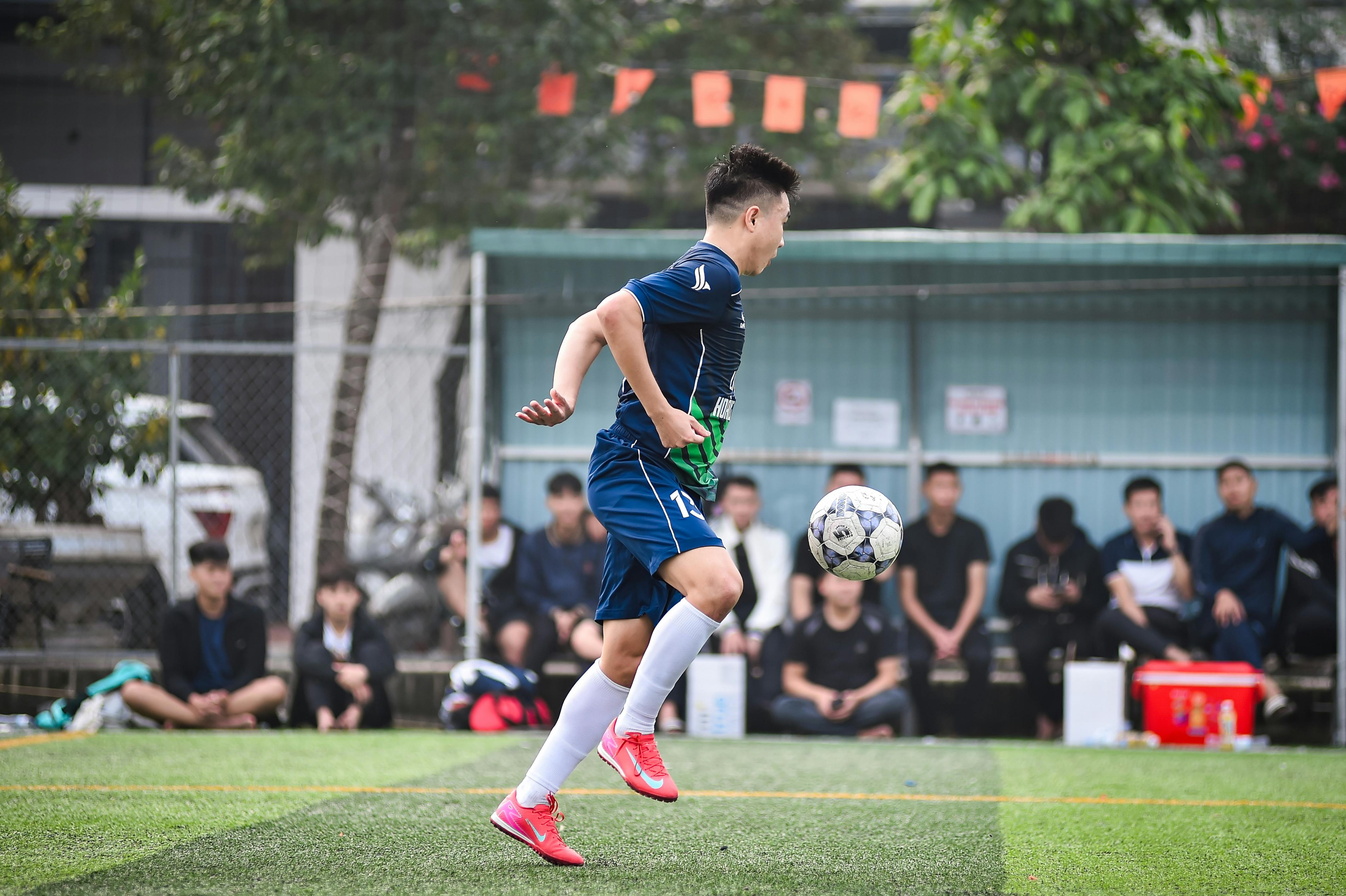 Soccer player in mid-air during a match on a Vietnam field.
