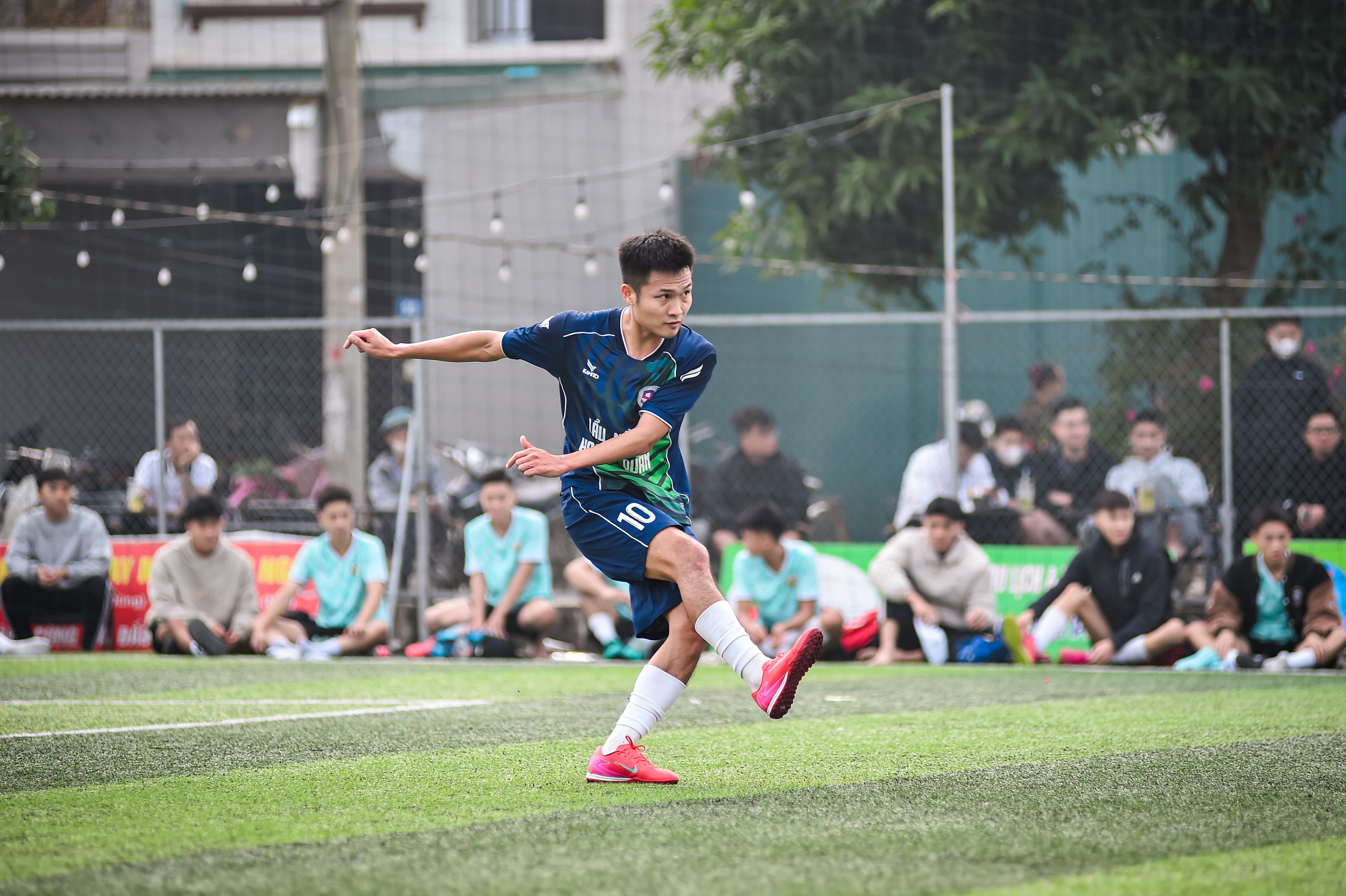 훈련 후 선수가 브러시로 축구화 스터드의 흙을 제거하고 통풍시키는 실내 장면