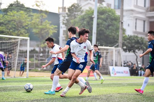Free Football players in action during a vibrant match on a sunny day in Hanoi, Vietnam. Stock Photo