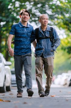Two men enjoy a leisurely stroll outdoors, embracing camaraderie and urban life.