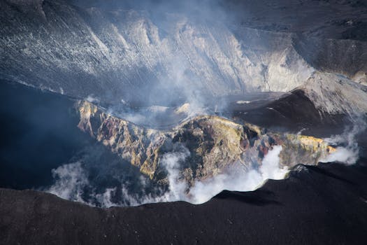 Aerial view of a steaming volcanic crater in Bali. Captured with dramatic lighting highlighting the rugged terrain.