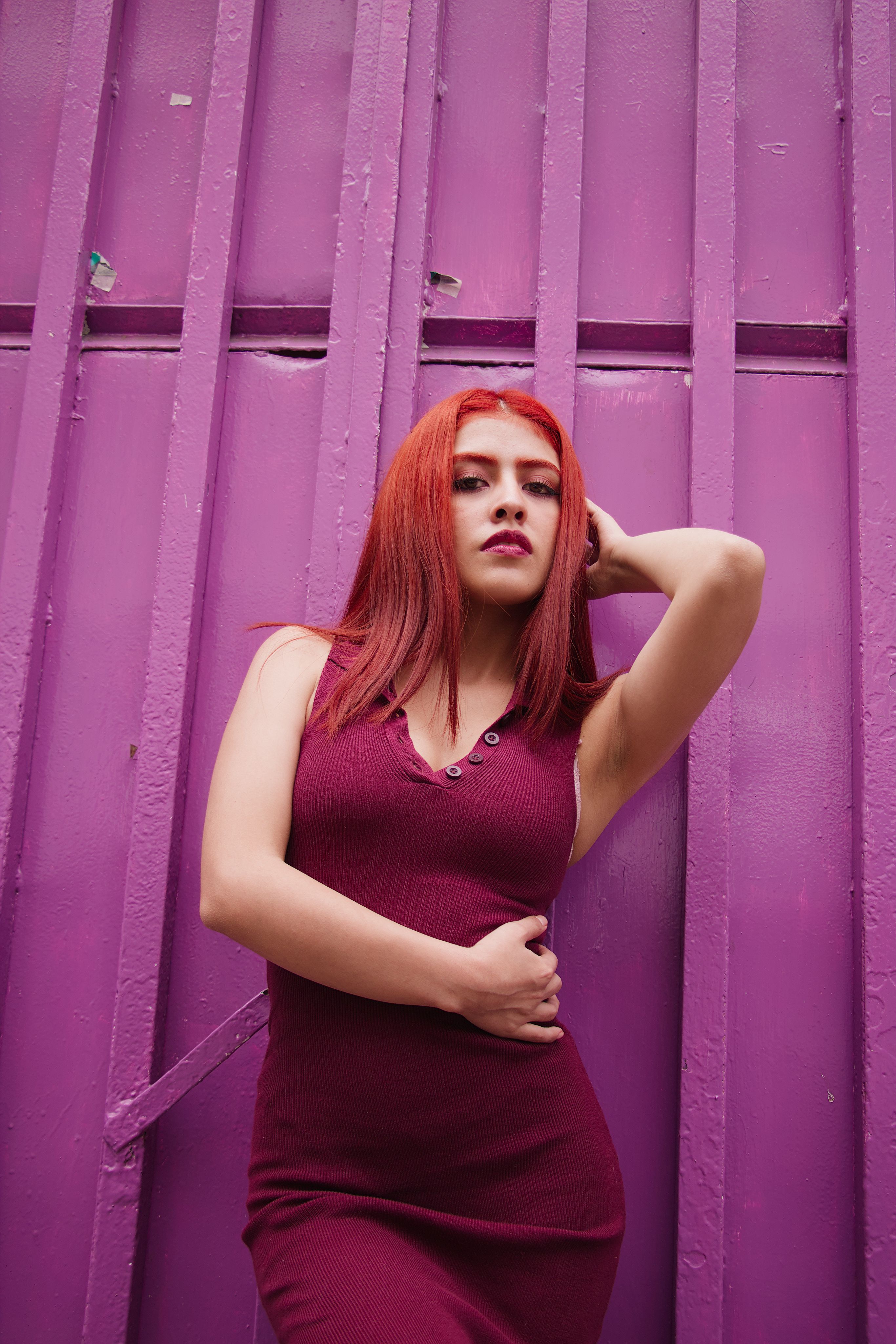 redhead in burgundy dress Red-haired woman in burgundy dress against purple wall · Free Stock Photo