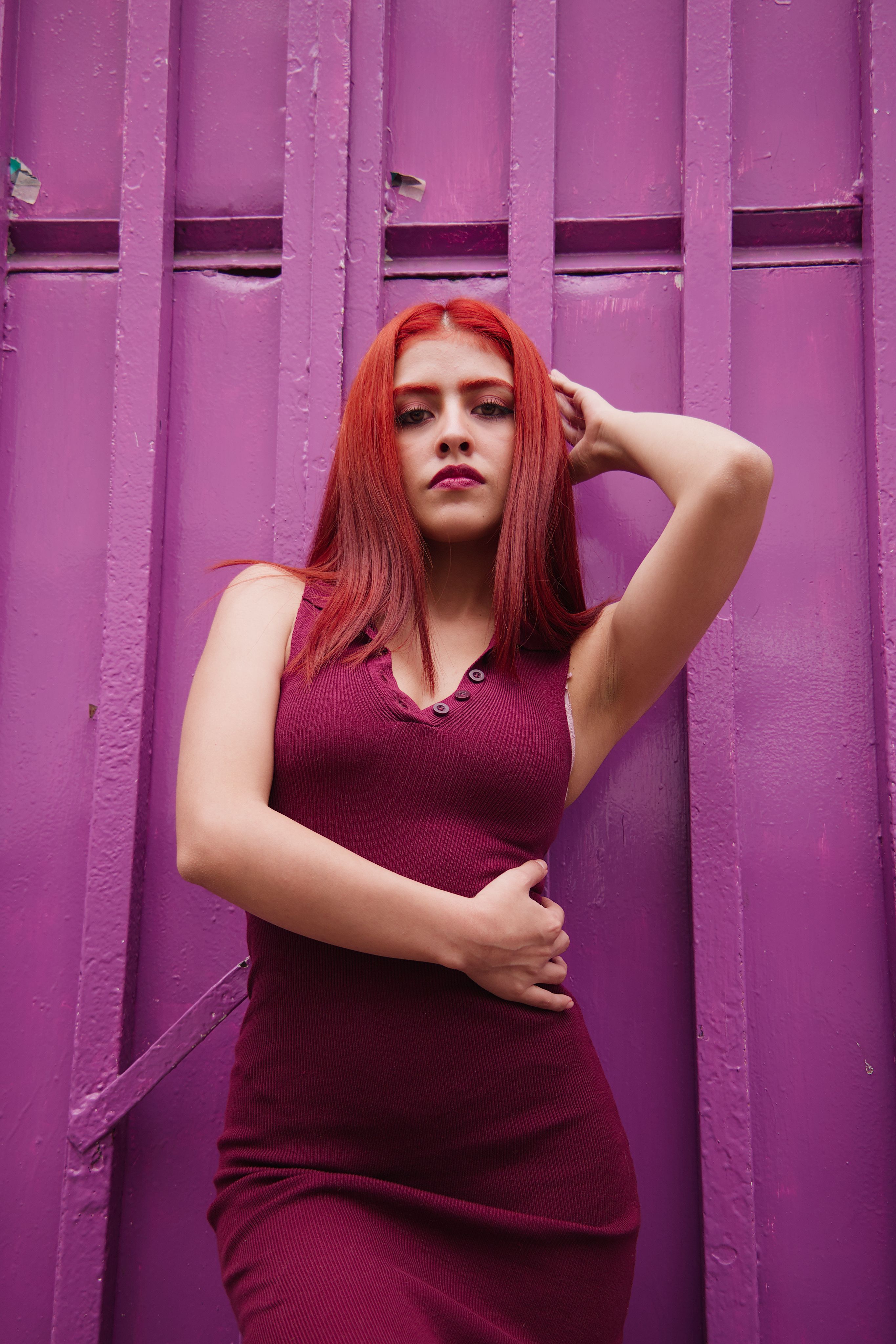 Stylish Redhead Woman Posing by Purple Wall  Free Stock Photo