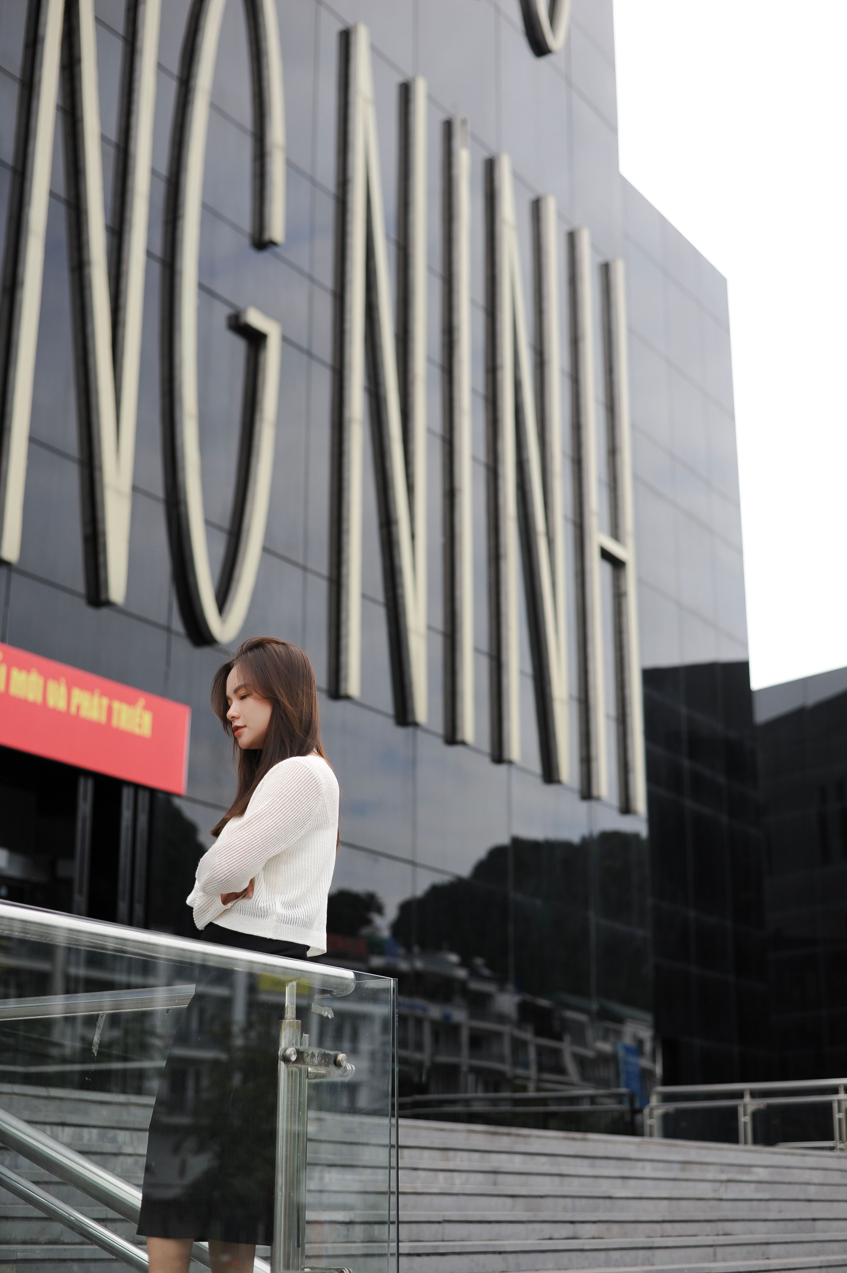 Quang Ninh Museum exterior reflecting light, modern black glass building near the sea