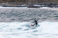 Captivating shot of a surfer riding the waves in Møre og Romsdal, Norway.