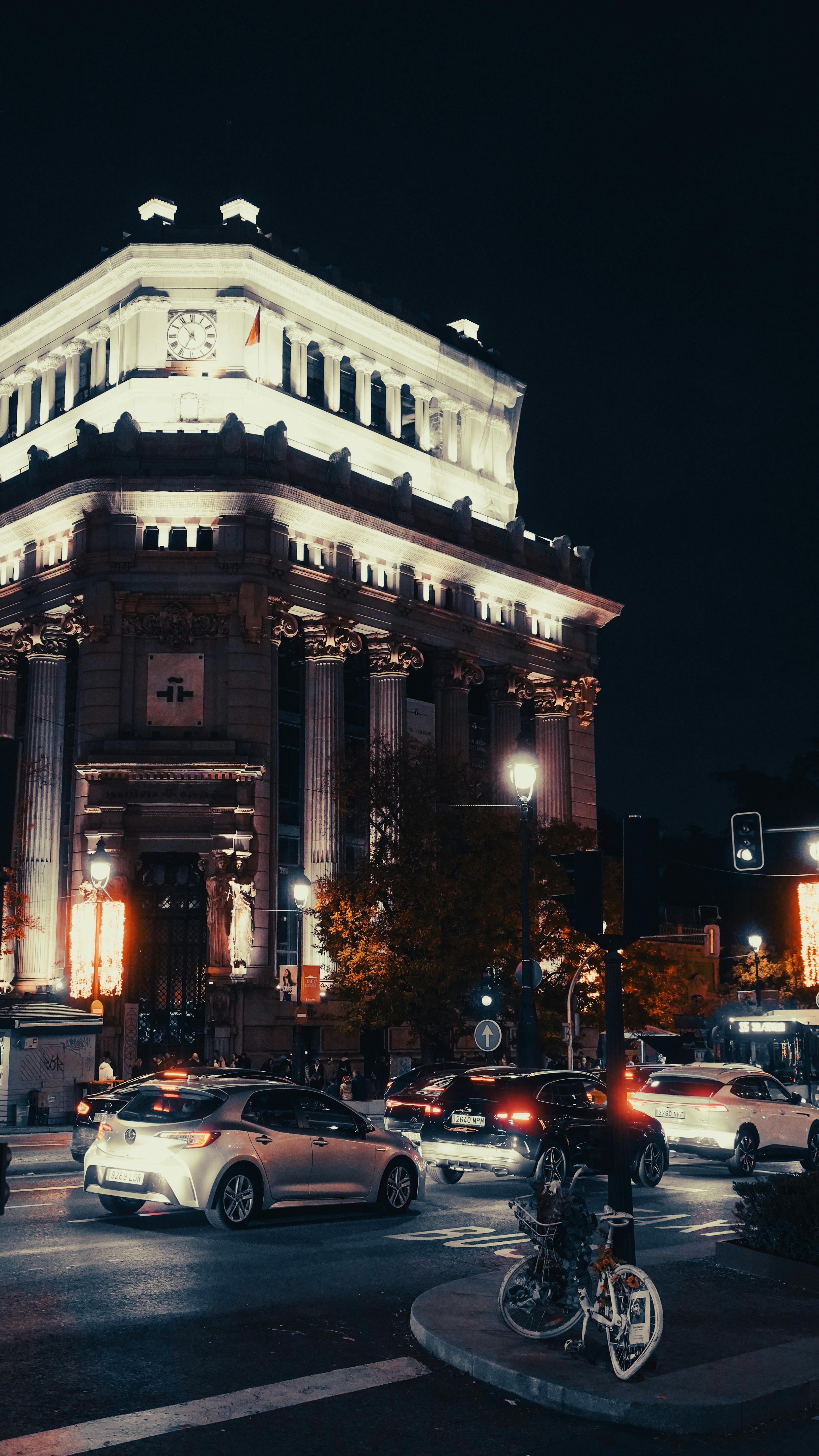 Free Night view of a neoclassical building with traffic in an urban setting. Stock Photo