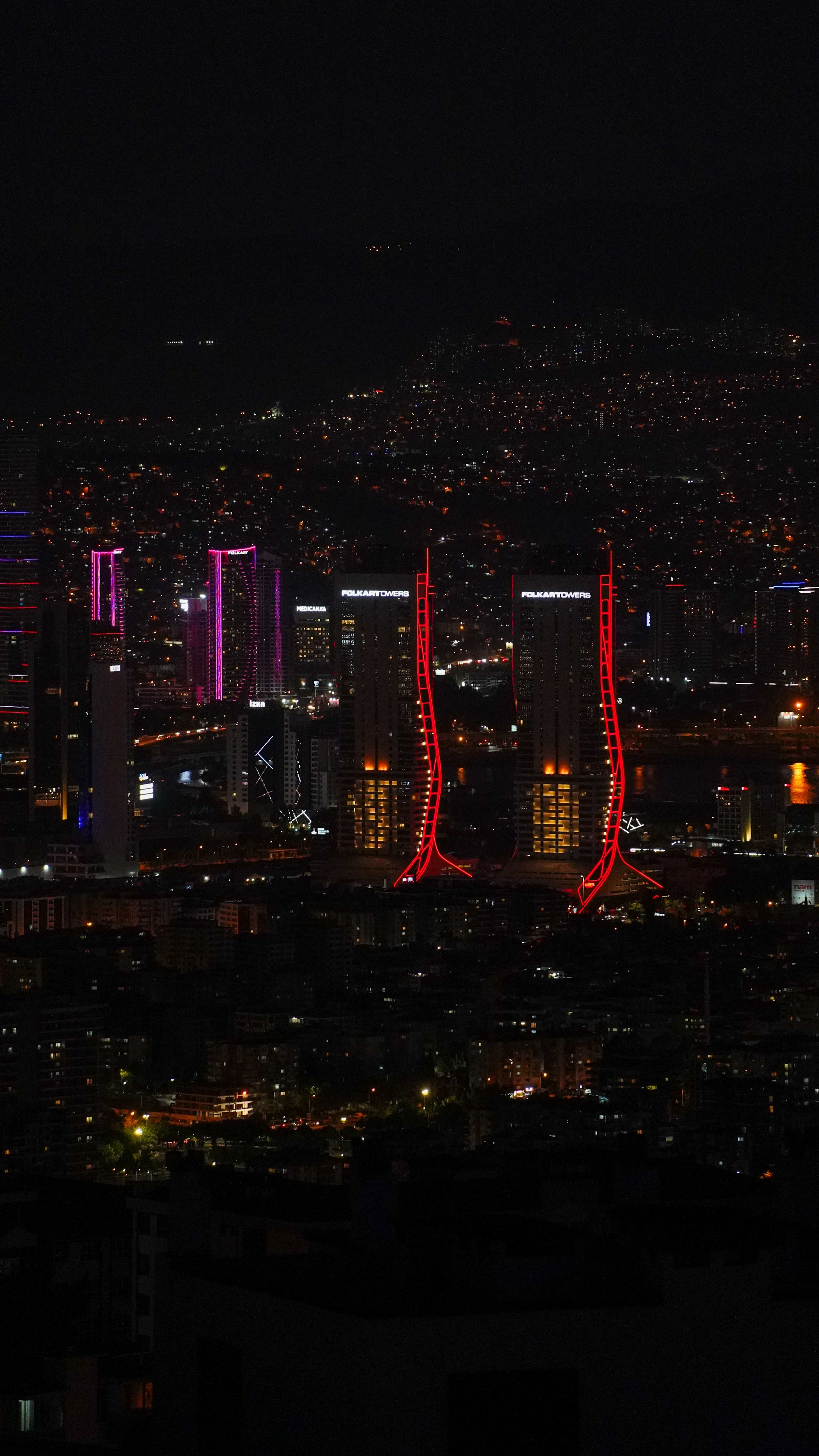 Vibrant city skyline with colorful illuminated skyscrapers at night.