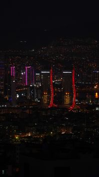 Vibrant city skyline with colorful illuminated skyscrapers at night.