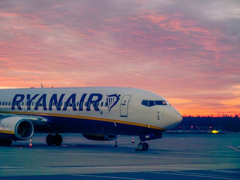 A Ryanair aircraft parked at Wrocław Airport during a stunning sunset.