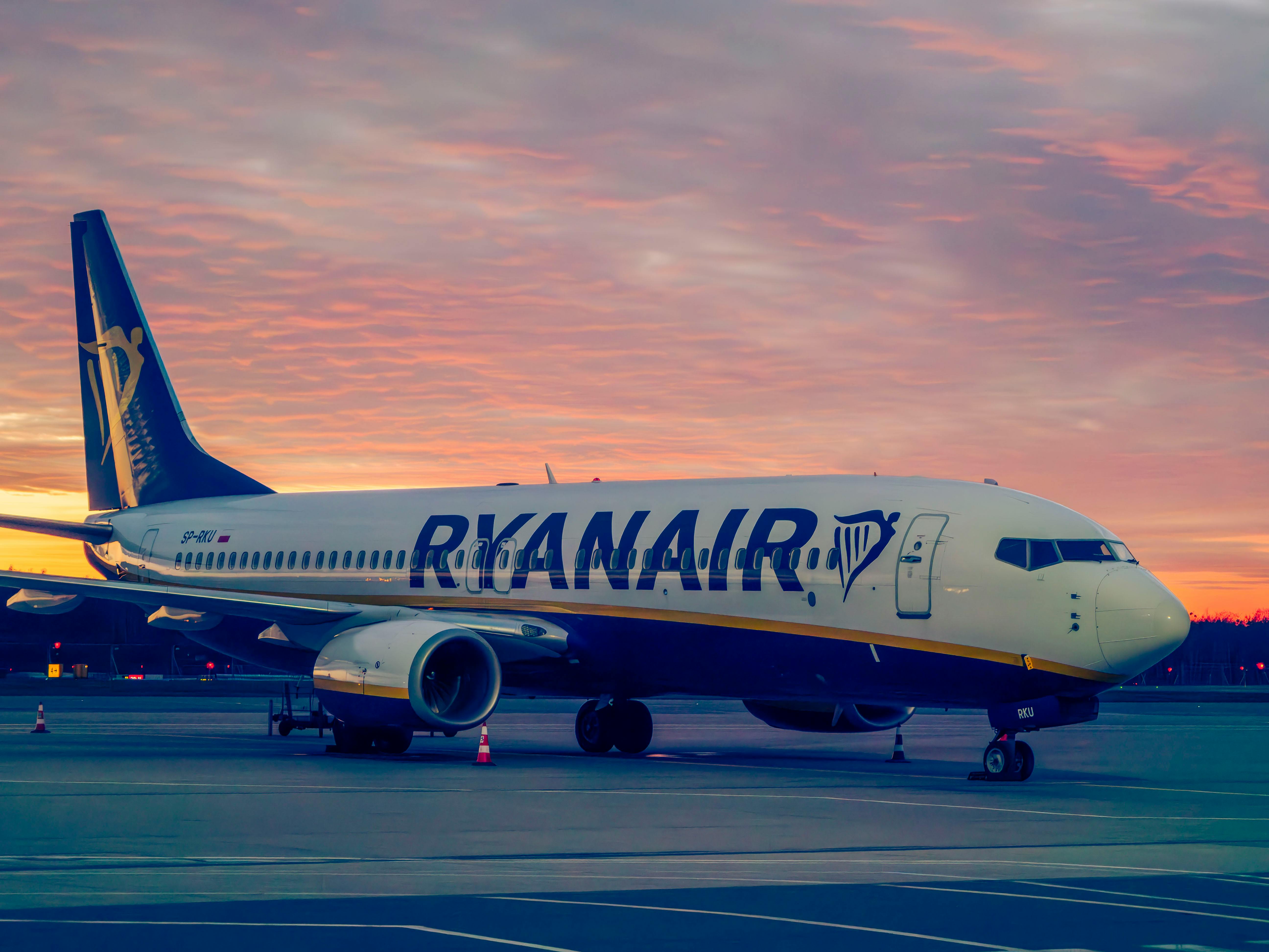 Free Ryanair aircraft parked at Wrocław Airport during a vibrant sunset. Stock Photo