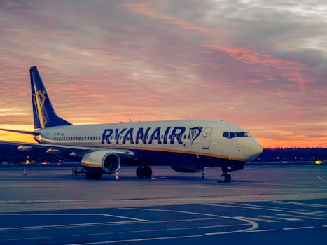 A Ryanair plane on a runway at sunset in Wrocław Airport, Poland.