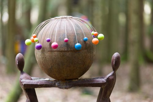 Free Unique sculpture with colorful elements in a serene forest setting. Stock Photo