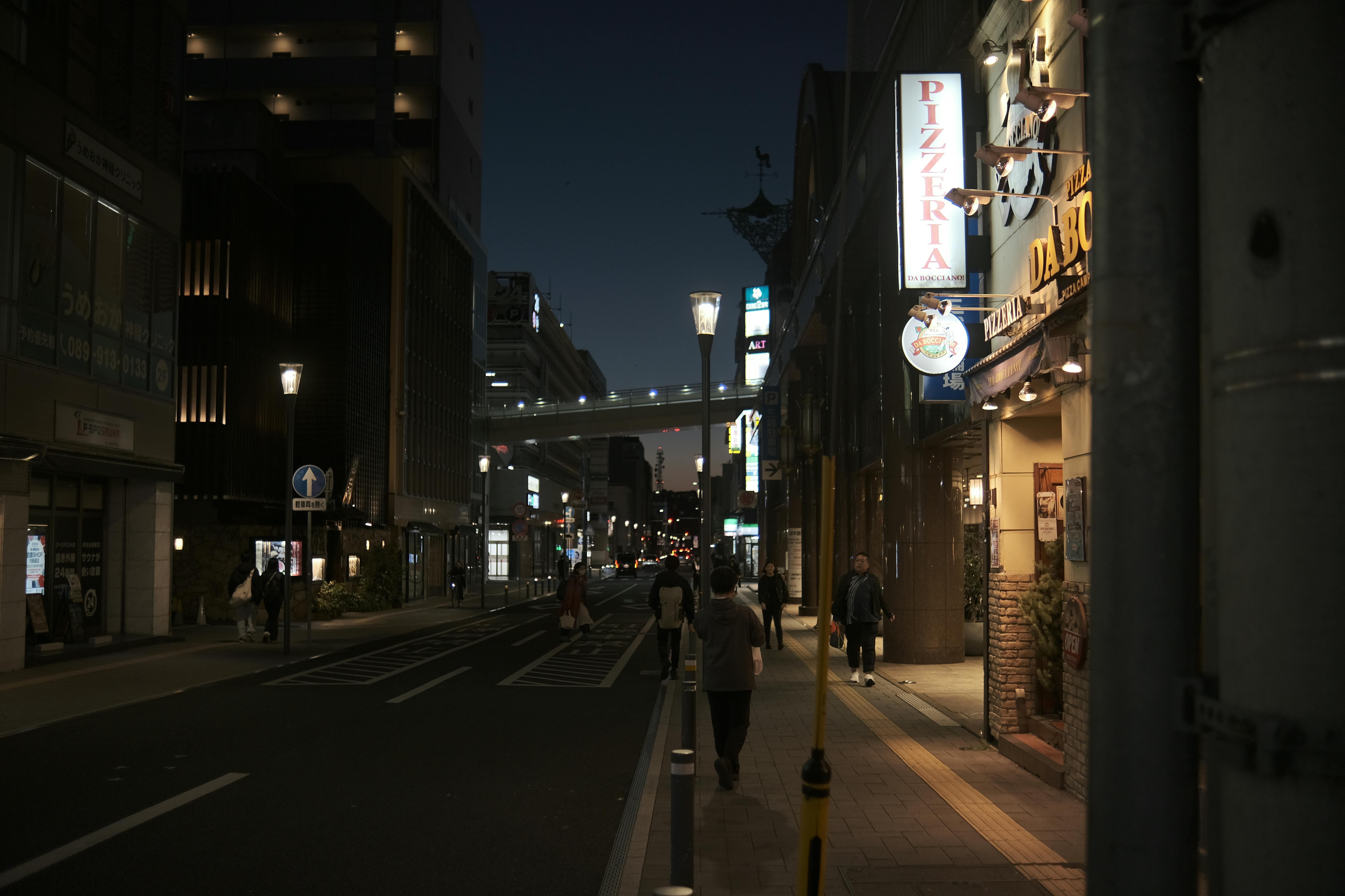 A well-lit city street at night with pedestrians walking comfortably - safest countries for solo travellers