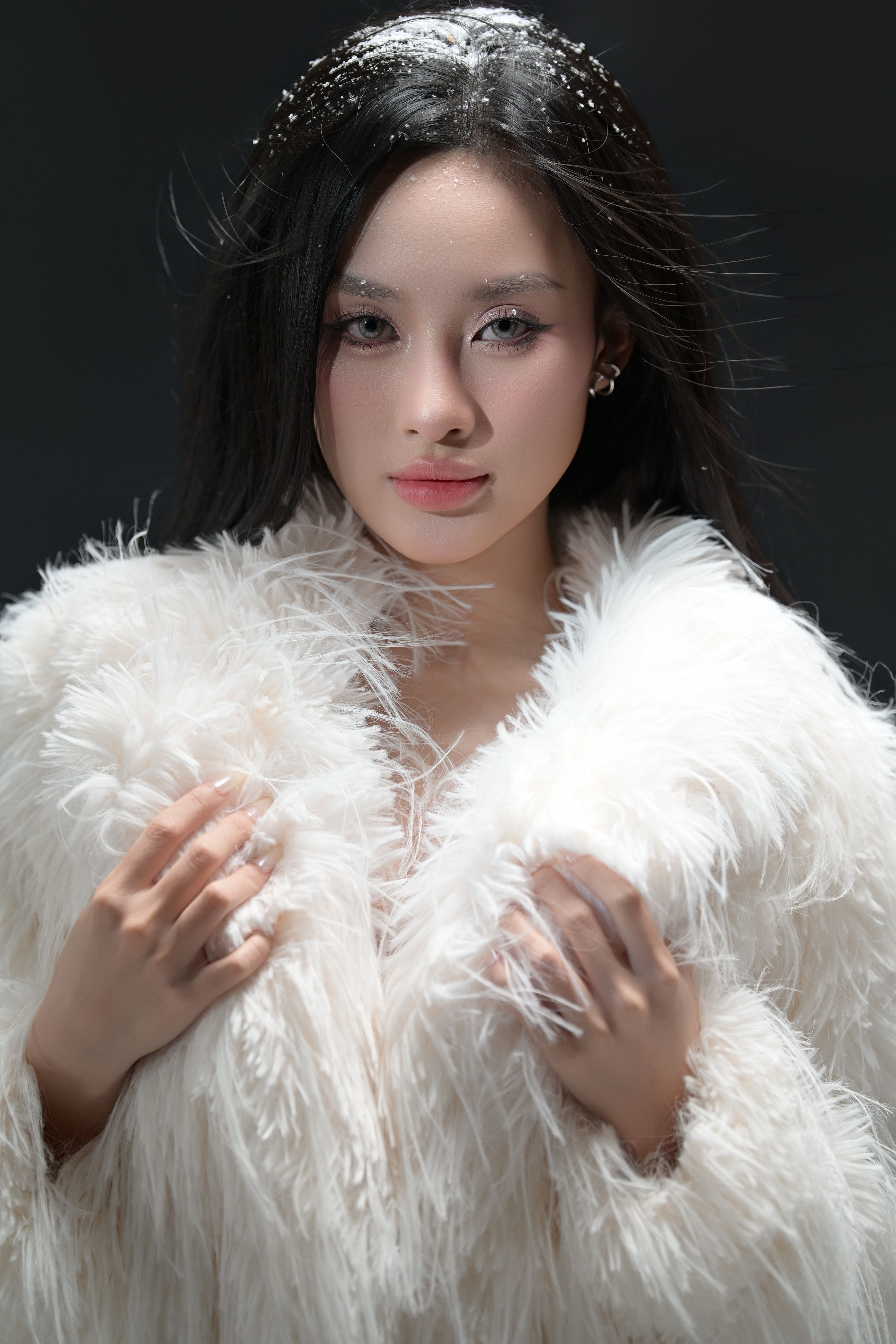 Elegant portrait of a woman wearing a stylish fluffy white coat.