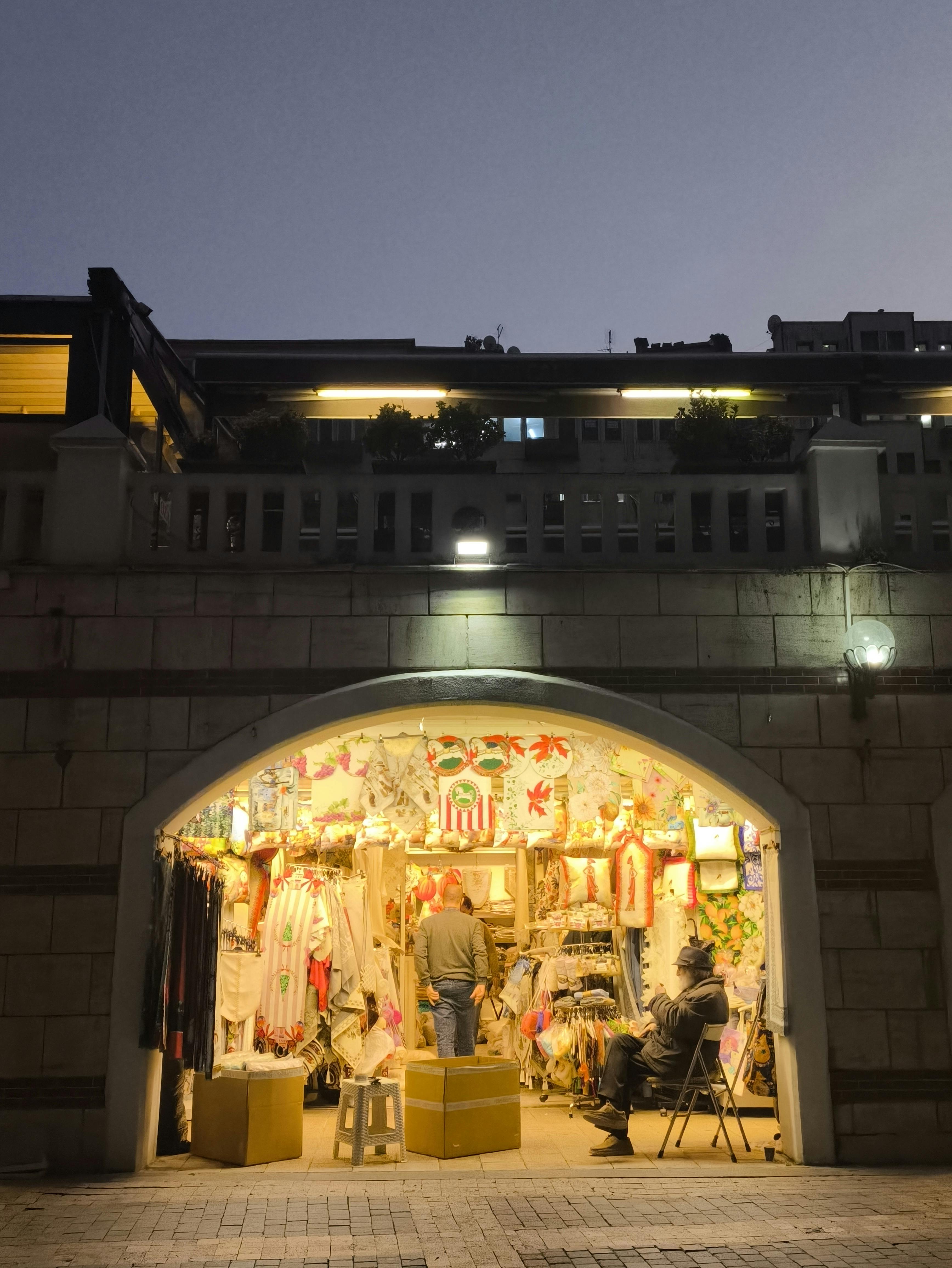 Cozy market stall offering goods at twilight under evening sky, urban atmosphere.