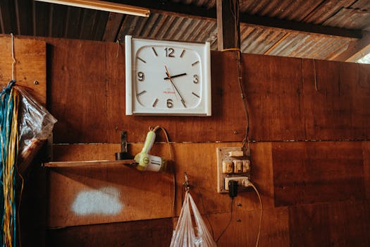 A wall clock hanging on a wooden wall in a rustic indoor setting, Kon Tum, Vietnam.