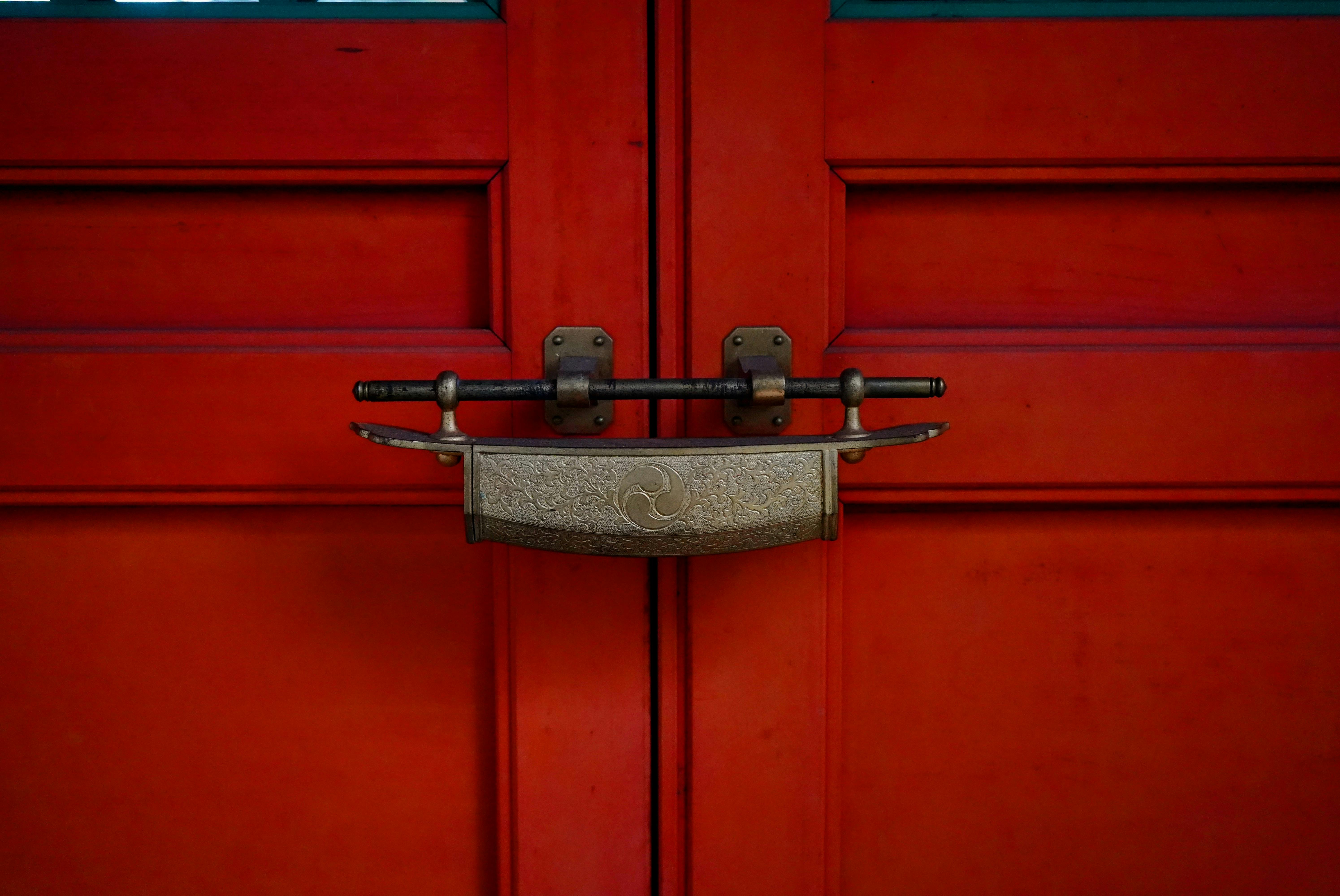 ingyenes Közeli kép egy dekoratív reteszről egy élénkpiros hagyományos faajtón. Stockfotó