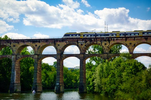 Train traversing historic viaduct in Bietigheim-Bissingen under bright summer sky.