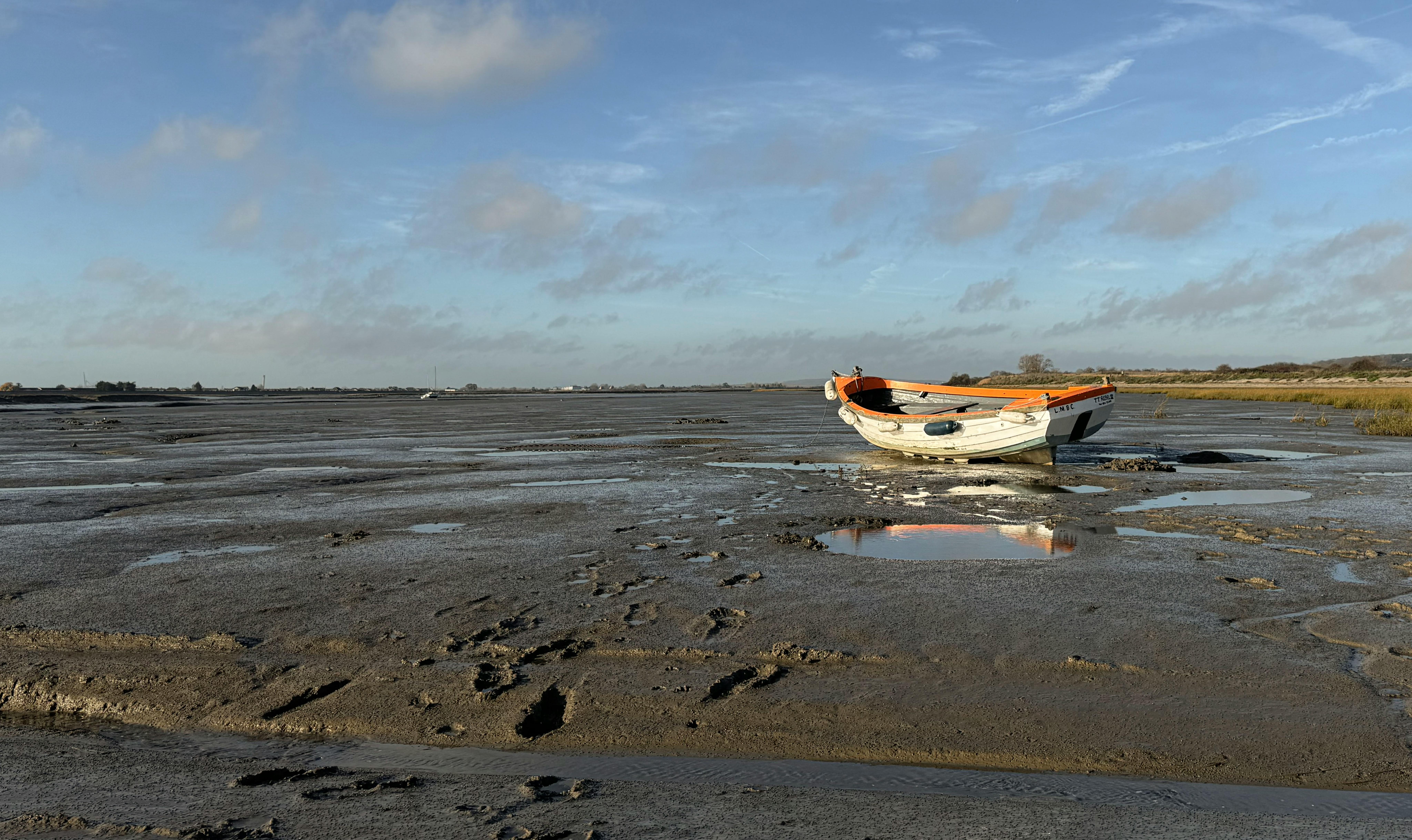 A lone boat rests on the mudflats during low tide in Southend-on-Sea, England.