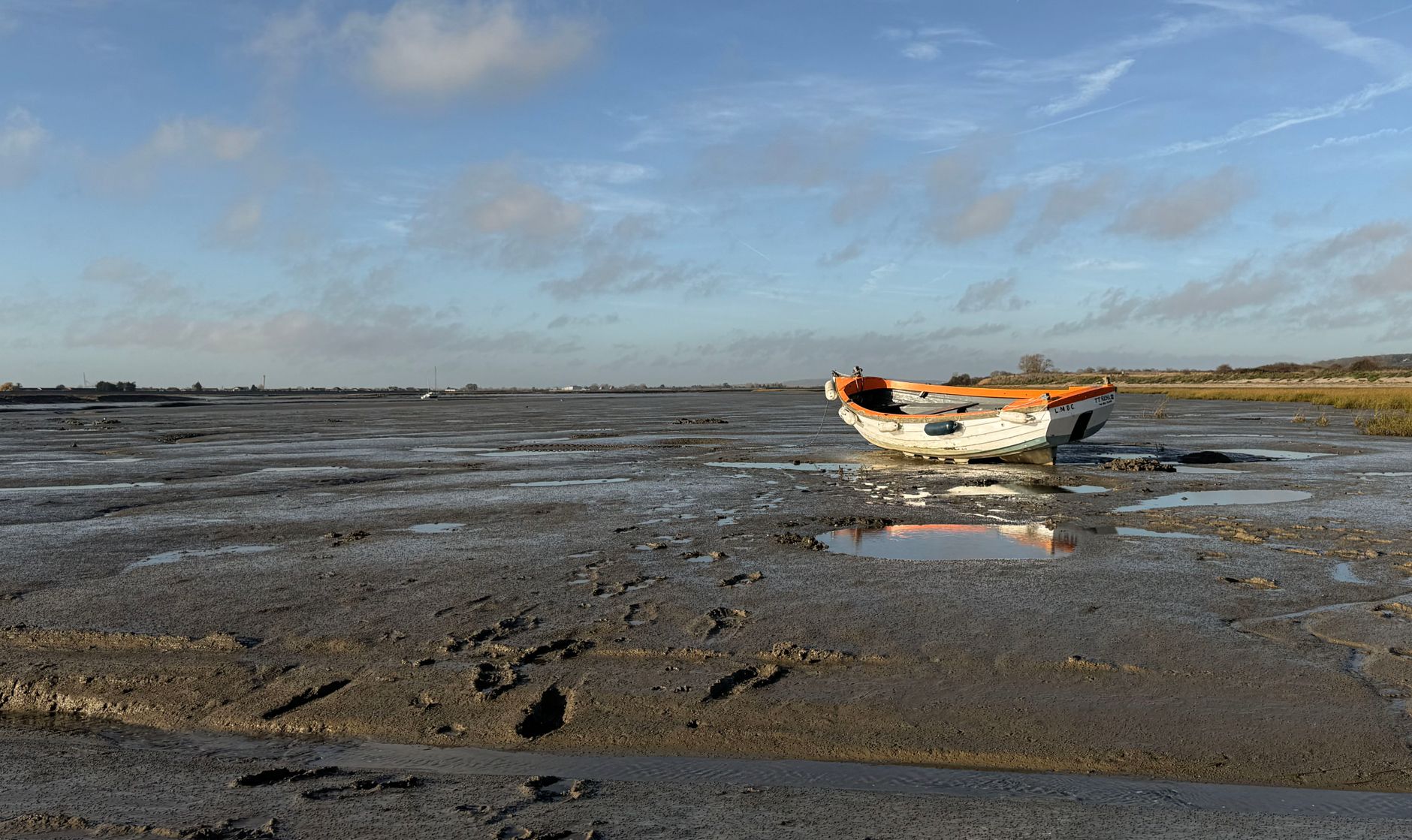 A lone boat rests on the mudflats during low tide in Southend-on-Sea, England.